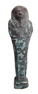 An Egyptian faience ushabti, Late Period: An Egyptian faience ushabti, Late Period, c. 664 - 332 BC, on integral base, mummiform wearing tripartite wig and false beard, arms folded at chest, hands holding a pick and how, vertical plinth down