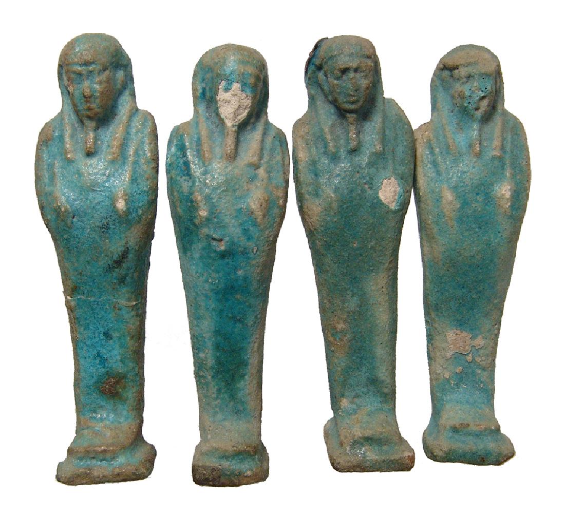 Group of 4 Egyptian blue glazed faience ushabtis: A group of 4 Egyptian blue glazed faience ushabtis, Late Period, c. 664 - 332 BC, all from the same burial, each depicted mummiform, wearing tripartite headdress with false beard, arms folded at chest