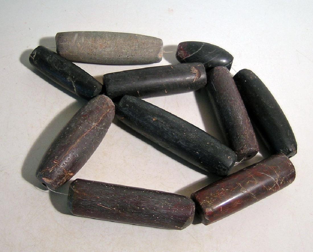 10 exceptionally large Tairona beads from Colombia: A strand of 10 exceptionally large Tairona beads from Colombia, c. AD 1000 - 1500, consisting mostly of dark jasper beads, up to 3 3/8 in in length. The strand is 28 1/2 in (72.2 cm) long overall. Ex 
