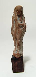 An Egyptian terracotta figure, Late Period: An Egyptian terracotta figure, Late Period, c. 664 – 30 BC, frontally molded and depicted wearing a kilt and tripartite headdress, right hand at breast and left arm pendant at side. Nicely detailed