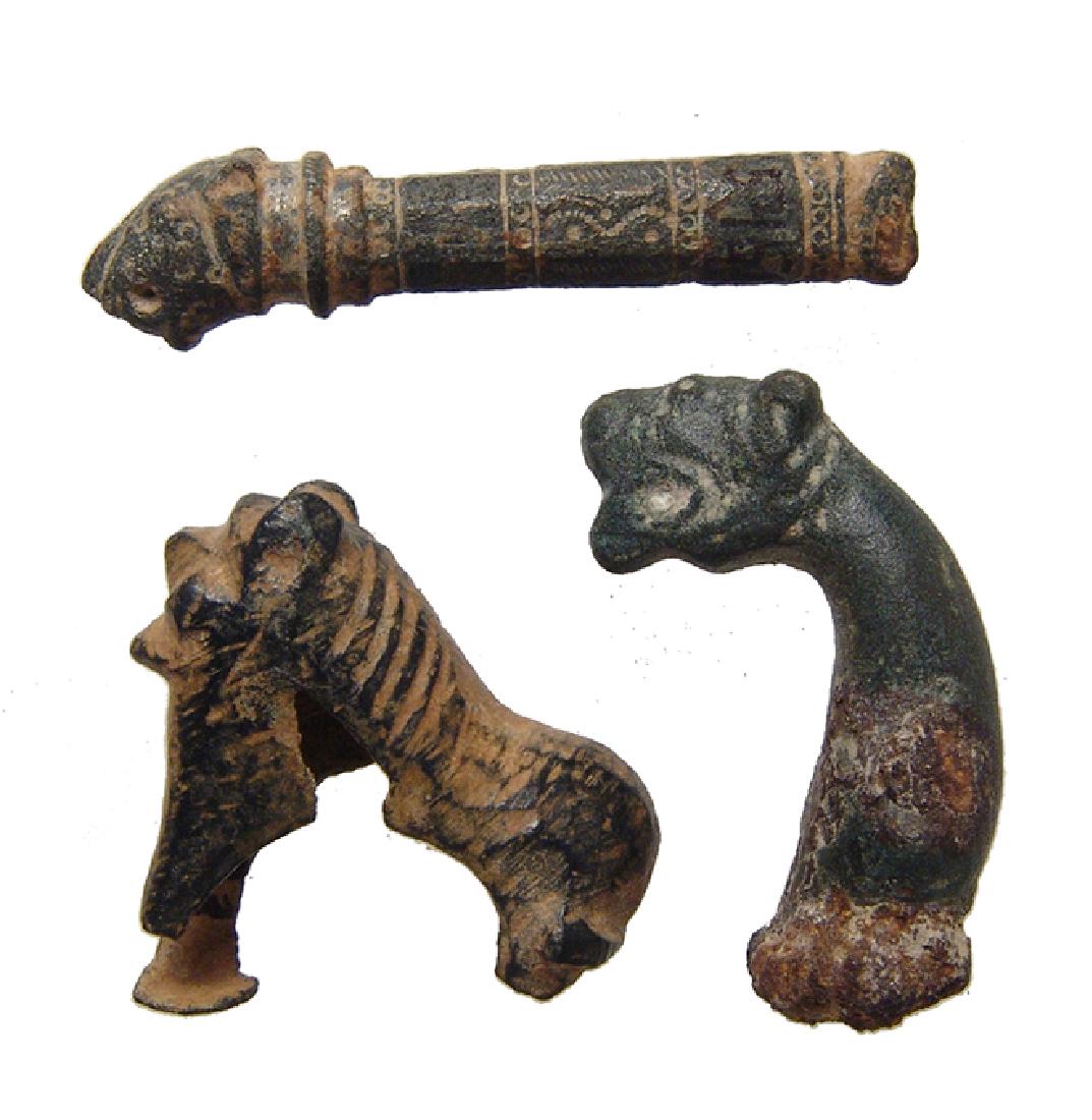 A trio of ancient bronze attachments in lion form (1 of 5)