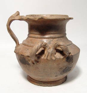 A beautiful Hellenistic ceramic olpe of unique form: A beautiful Hellenistic ceramic olpe of unique form , c. 3rd - 1st Century BC, in imitation of metal ware, with squat body and twisted loops around the shoulder, the handle quite decorative with