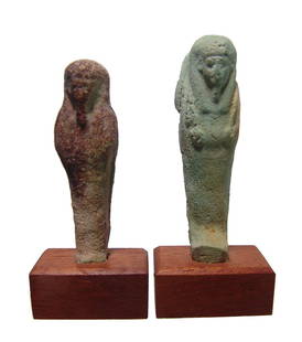 A pair of Egyptian faience ushabtis, Late Period: A pair of Egyptian faience ushabtis, Late Period, c. 664 - 30 BC, both frontally molded, one with a nice light blue glaze and both mounted on antique rectangular wood bases. H: 2 5/8 in (6.8 cm) and 2