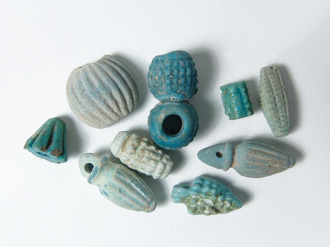A group of 10 Egyptian faience beads and amulets: A group of 10 Egyptian faience beads and amulets. Most date from the Late Period, c. 664 - 30 BC, and include a variety of types, shapes and sizes, and one from the Roman Period, c. 1st - 2nd Century