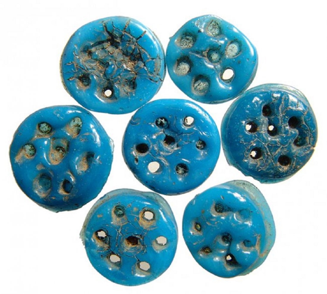7 Egyptian blue faience rosettes, Ptolemaic Period: A group of 7 Egyptian blue faience rosettes, Ptolemaic Period, c. 332 - 30 BC, each frontally molded with six circular depressions surrounding a central one. Each are very well-preserved with vibrant