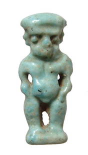 A detailed Egyptian faience amulet of Pataikos: A detailed Egyptian faience amulet of Pataikos, Late Period, c. 664 - 30 BC, standing nude on integral base, his features well-modeled and with well-preserved pale blue glaze. H: 1 1/8 in (2.8cm). Ex