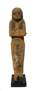 Egyptian wooden ushabti, Late New Kingdom: An Egyptian wooden ushabti, Late New Kingdom, c. 1200 - 1075 BC, retaining much of its original pigment. The ushabti is depicted mummiform, wearing tripartite wig, arms folded at chest, hand with