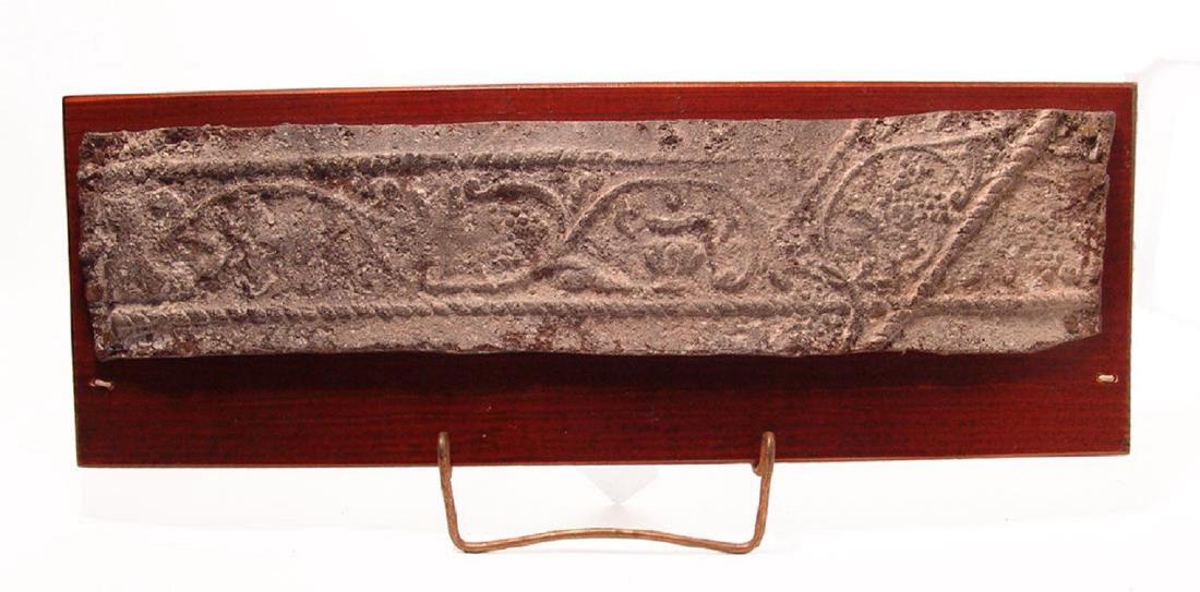 Roman lead sarcophagus panel, Holy Land: A Roman lead sarcophagus panel, Holy Land, 1st - 3rd Century AD, containing a frieze with central amphora and grape wine bordered and crossed diagonally on right end by a rope pattern. 17 in x 3 7/8 i