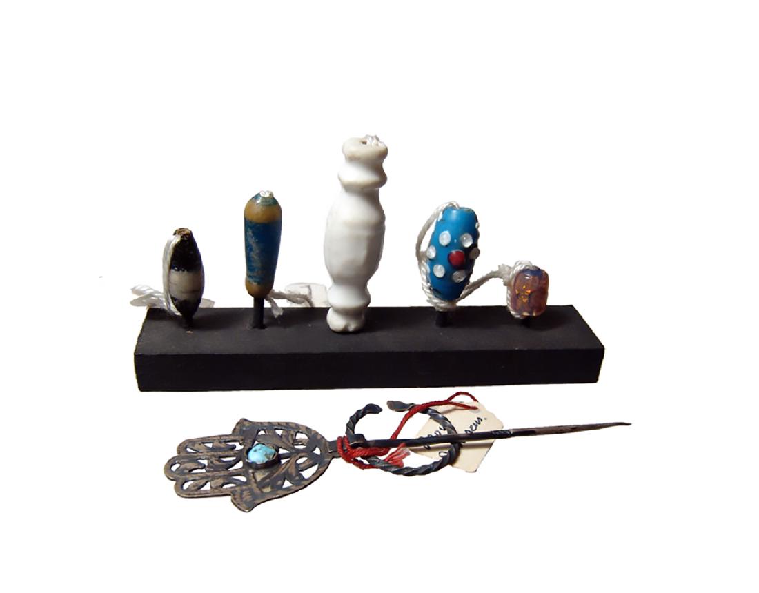 5 Mounted glass beads and a 'Hand of Fatima' brooch: A mixed lot of 5 mounted and labeled glass beads and a 'Hand of Fatima' brooch. The various beads are nice examples and date from the Late Period of Egypt to the Islamic era, with a nice Roman white b