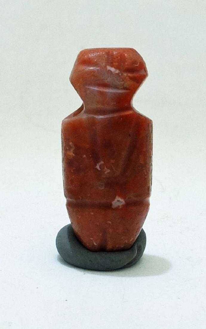 An excellent Tairona figural pendant from Colombia: An excellent Tairona figural pendant from Colombia, c. AD 1000 - 1500. It is 1 1/8 in long and is carved from highly polished carnelian. Choice example. Ex New World Artifacts Gallery.