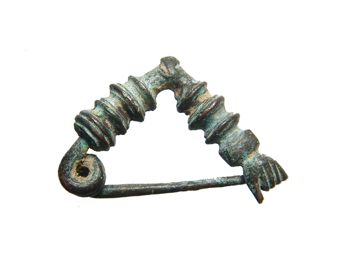 A very nice Persian bronze 'Hand' fibula: A very nice Persian bronze 'Hand' fibula, c 3rd - 2nd Century BC, the body triangular in shape and adorned with ridges, the original pin is present with pin catch in the form of a human hand. L: 1 3/8