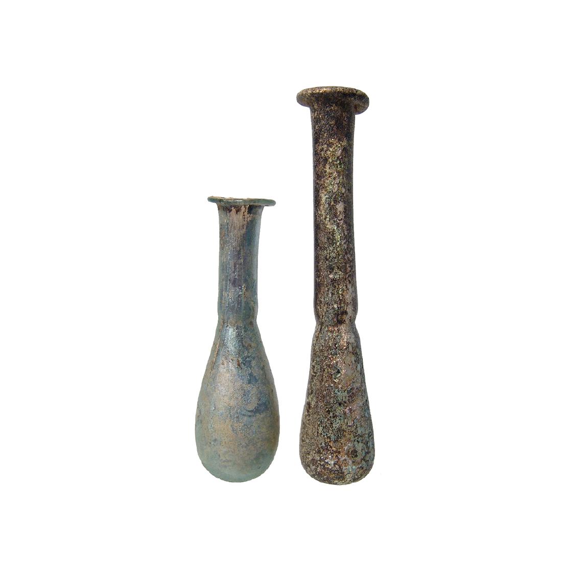 A pair of attractive Roman glass bottles: A pair of attractive Roman glass bottles, 1st - 2nd Century AD, both in near colorless glass, each with ovoid body and long cylindrical neck with constricted base the mouth flared with inward folded r