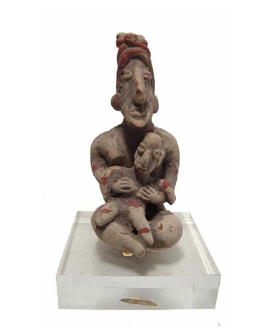 Jalisco terracotta figure of a seated mother and child: A Jalisco terracotta figure of a seated mother and child, West Mexico, c. 250 BC - AD 250, nicely modeled, her angular head with elaborate headdress, coffee-bean eyes and prominent nose, she holds a c