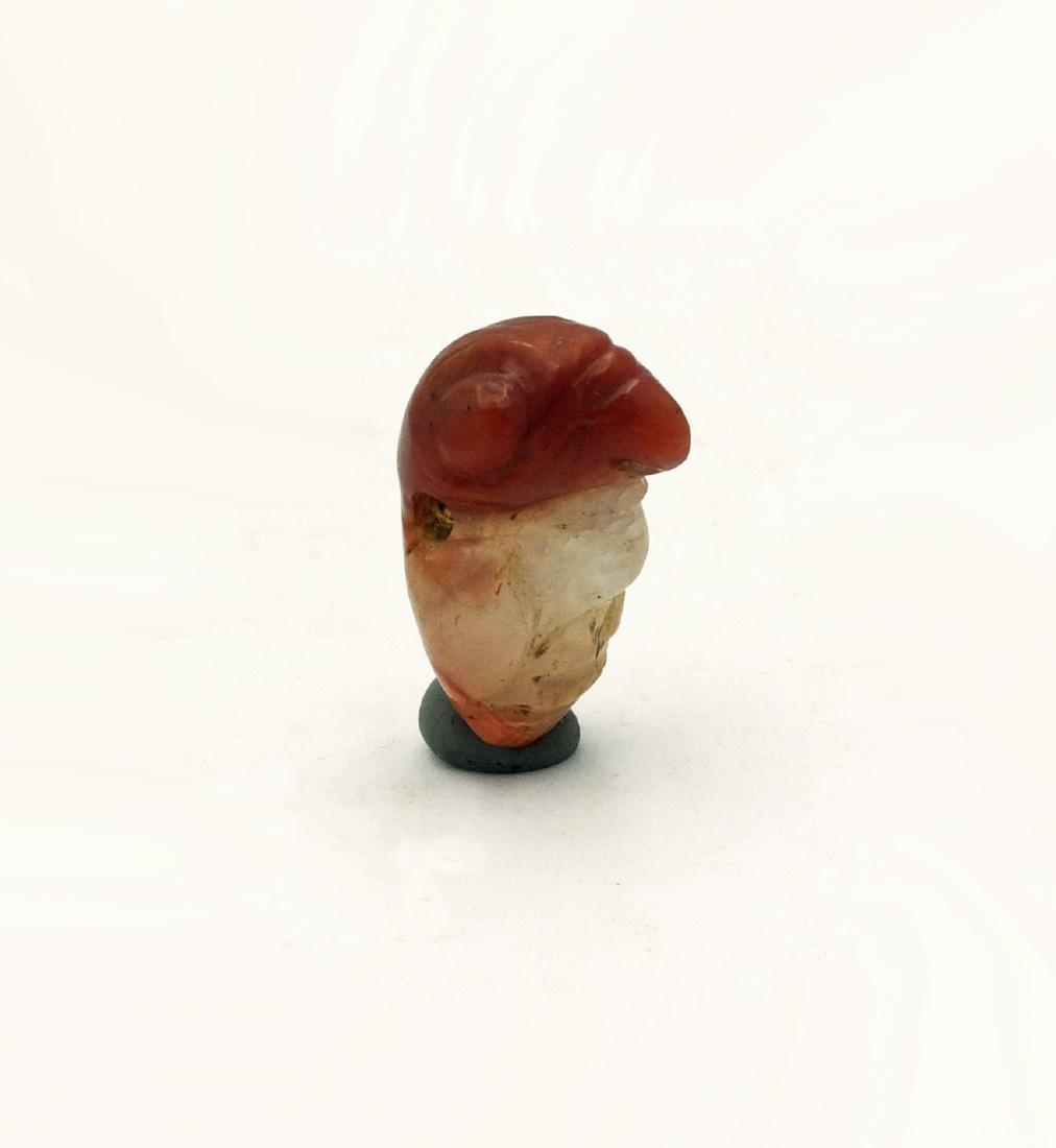 A choice Tairona carnelian pendant from Colombia: A choice Tairona carnelian pendant from Colombia, c. AD 1000 - 1500. This large example is 1 1/8 in high and depicts a beautifully detailed bird. Masterful usage of the color variations in the stone t