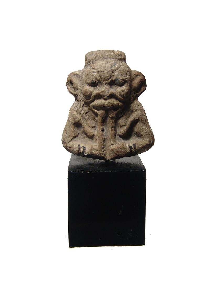 A wonderful Egyptian faience depiction of Bes: A wonderful Egyptian faience depiction of Bes, Late Period, c. 664 - 30 BC, the upper portion of a figure, his leonine features beautifully detailed and playing flutes, a larger hole atop the head for