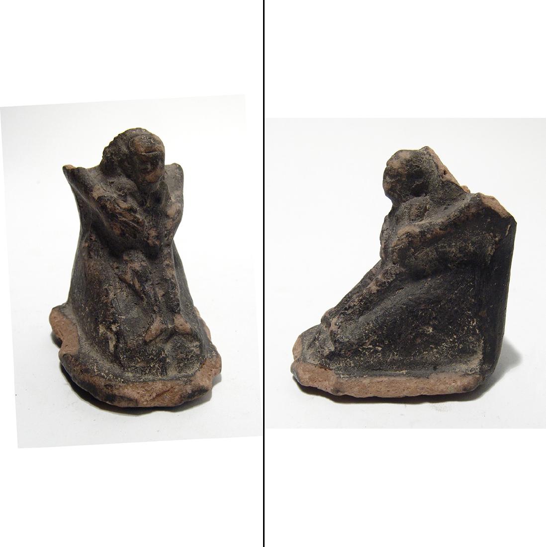 Egyptian terracotta kneeling figure holding child: An Egyptian terracotta kneeling figure holding child, Late Period, c. 664 - 30 BC, the youthful figure, perhaps Horus, is nude wears tripartite headdress, the piece in entirely slipped in dark brown w
