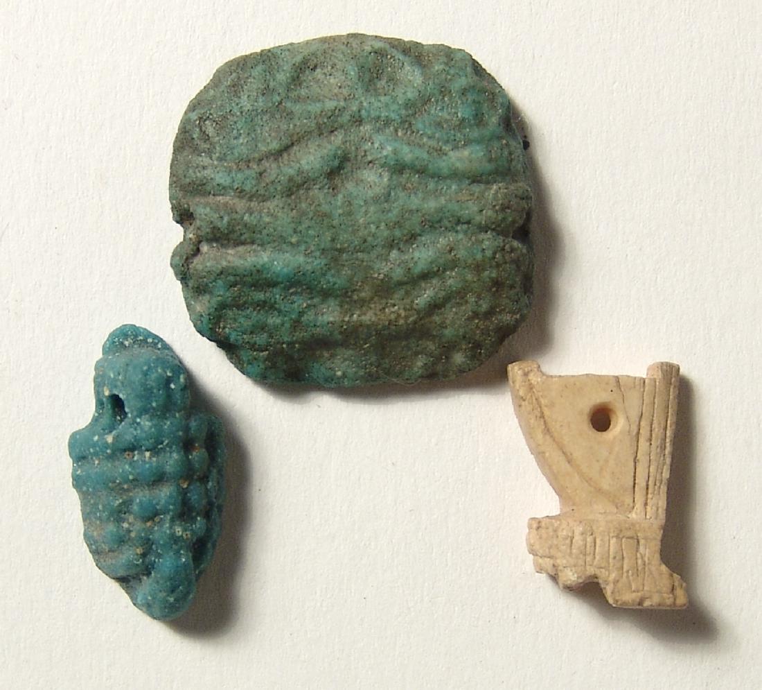 A group of 3 Egyptian amulets: A group of 3 Egyptian amulets. The first two date from the Late Period, c. 664 - 30 BC, and include a steatite amulet of the red crown, 18 x 12 mm, and a faience multiple Eye of Horus amulet of roughl