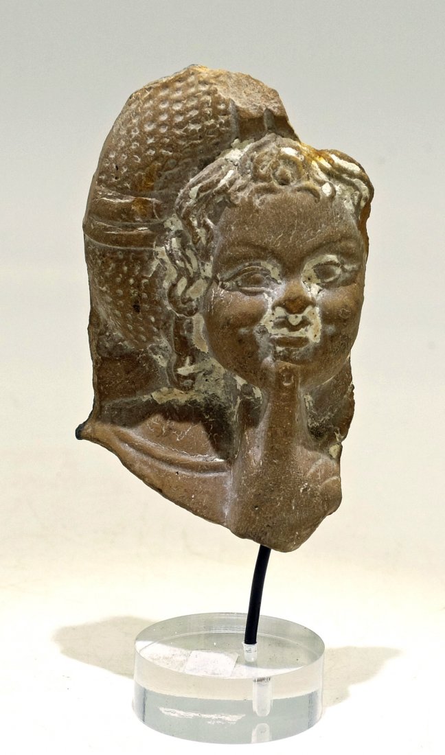 Detailed Roman-Egyptian terracotta bust of Harpokrates: A nicely detailed Roman-Egyptian terracotta bust of Harpokrates, c. 1st - 2nd Century AD, depicting Harpokrates with long curly hair and a finger held to his lips in the characteristic pose. H: 3 in (