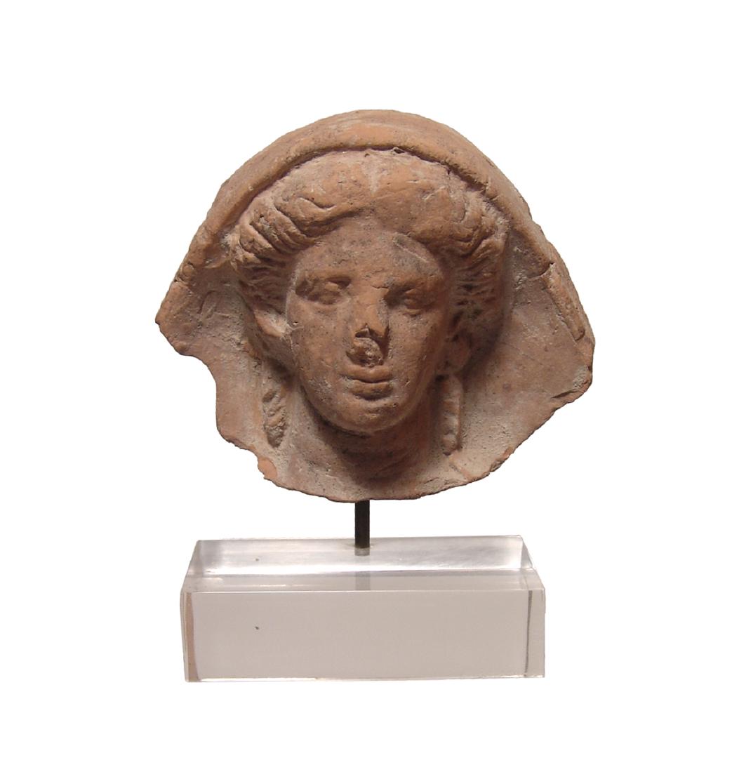 A beautiful Etruscan terracotta votive head: A beautiful Etruscan terracotta votive head, c. 4th Century BC, in the form of a veiled woman, her features beautifully modeled and wearing a choker and earrings, her hair parted in middle and styled 