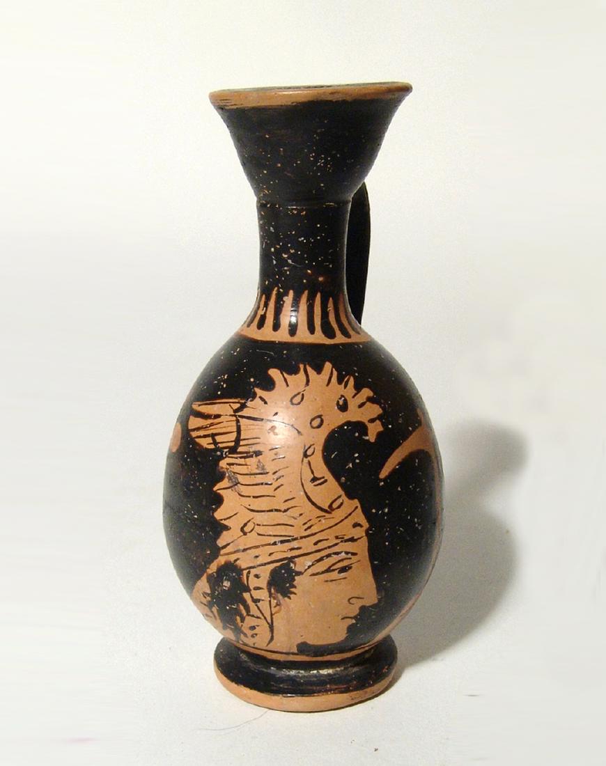 Lovely Campanian red-figure lekythos with an Amazon: A lovely Campanian red-figure lekythos depicting an Amazon in profile, South Italy, c. 4th Century BC, facing right, wearing a high dragonate helmet and holding an axe in front of her, H: 4 in (10.2cm