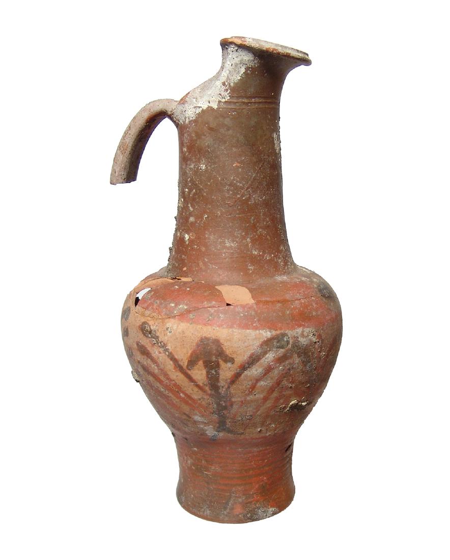 An Etruscan black-figure beaked oinochoe: An Etruscan black-figure beaked oinochoe, 400 - 375 BC, with cut-away neck and vertical strap handle. The upper portion of the vessel is slipped, the lower portion decorated with a palmette frieze. H: