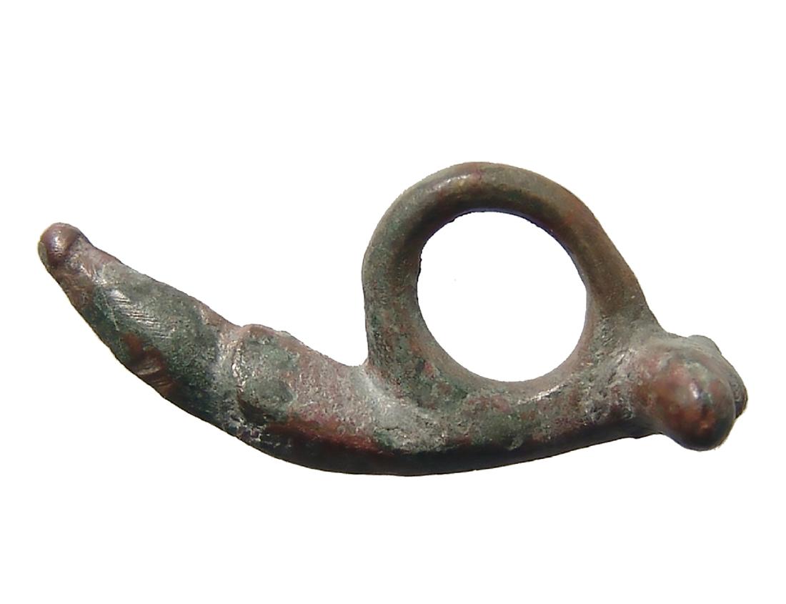 A Roman bronze phallic amulet: A Roman bronze phallic amulet, c. 1st - 3rd Century AD, of natural style with large suspension loop. L: 1 5/8 in(4.1 cm). Nicely patinated and suspended from lamps and similar for warding off evil and