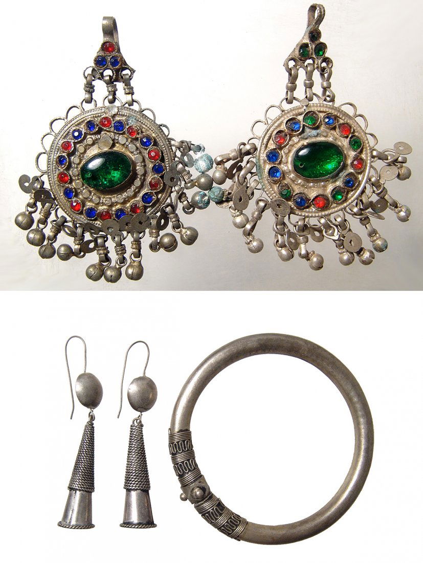 Antique silver jewelry from Nepal & Afghanistan: A group of antique silver jewelry. Lot includes an ornate pair of silver earrings, Afghanistan, 19th Century, circular in shape with central green glass cabochon bordered by faceted multicolored glass