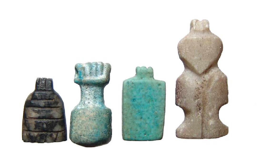 A group of 4 stone and faience Egyptian amulets: A group of 4 stone and faience Egyptian amulets, Late Period, c. 664 - 30 BC, and include an alabaster amulet of stylized Pataikos, a blue-green faience palette, a steatite comb amulet and a blue-gree