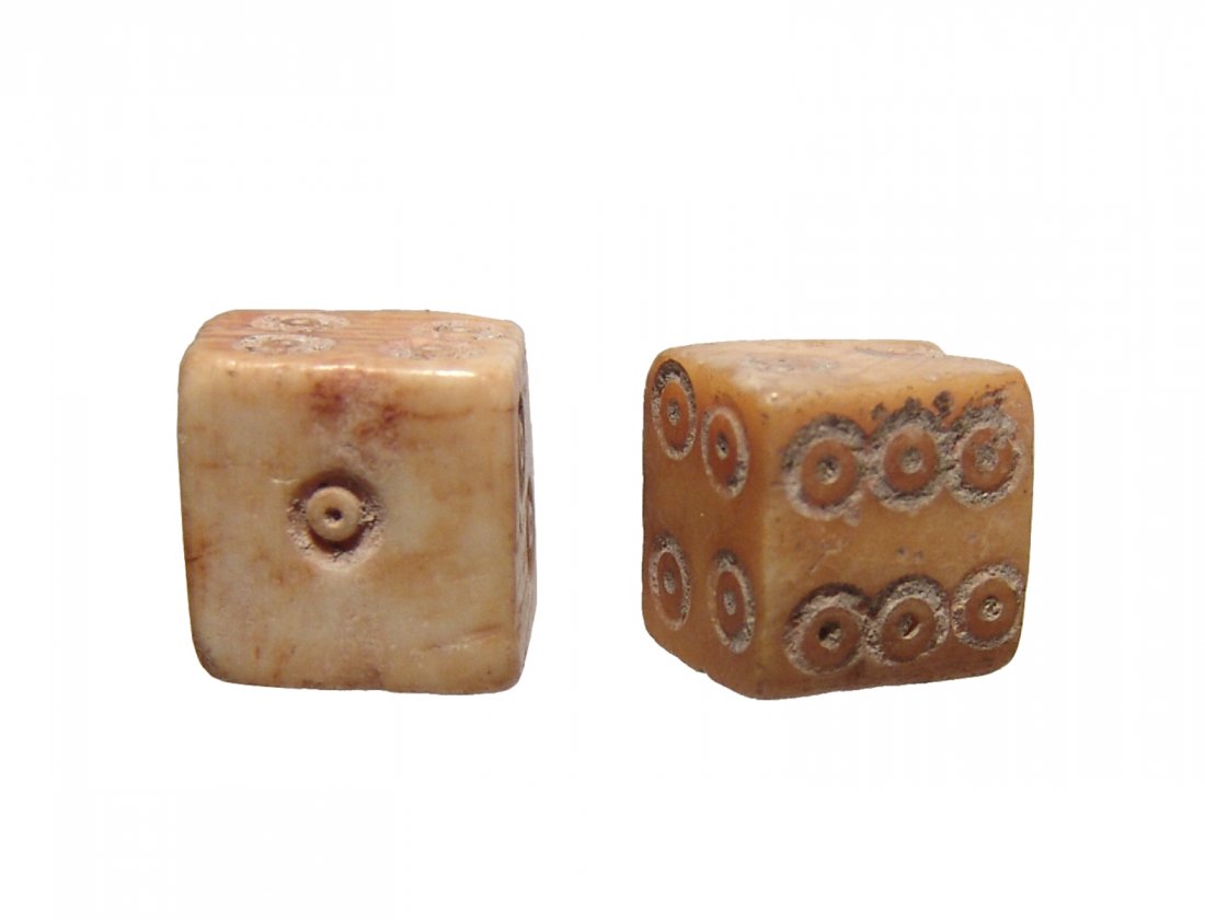 A pair of Roman bone dice: A pair of Roman bone dice, c. 1st - 3rd Century AD, of classic form with drilled circles around a central divot aligned 1 - 6 on the six sides. The sides average 12mm in width and are nice examples of
