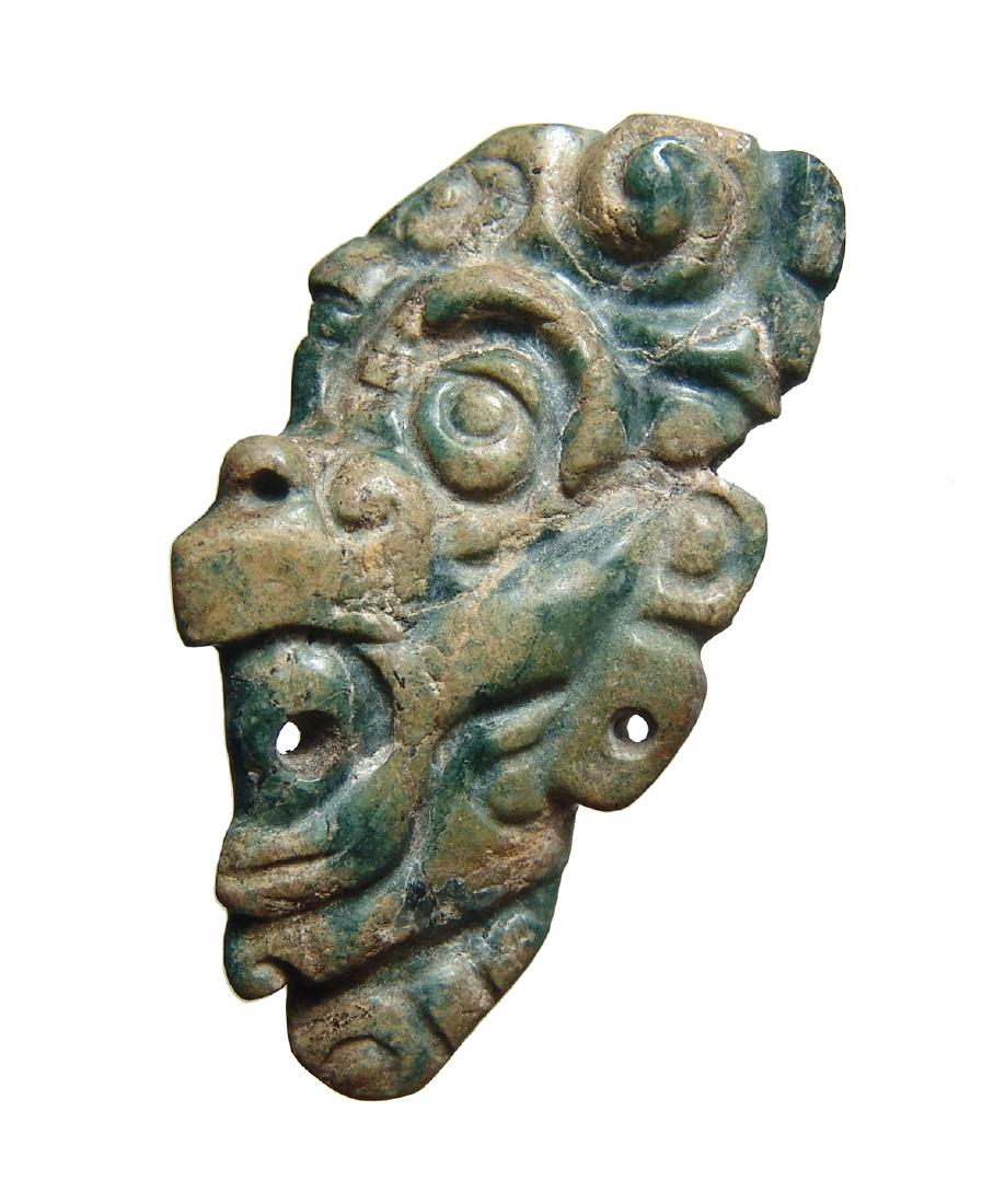 Mayan jade pendant in form of head of supernatural: An intricate Mayan jade pendant in form of head of supernatural being, c. AD 600 - 800, seen in profile and beautifully carved with exaggerated features - large eye, bird-like beak amidst swirls and c