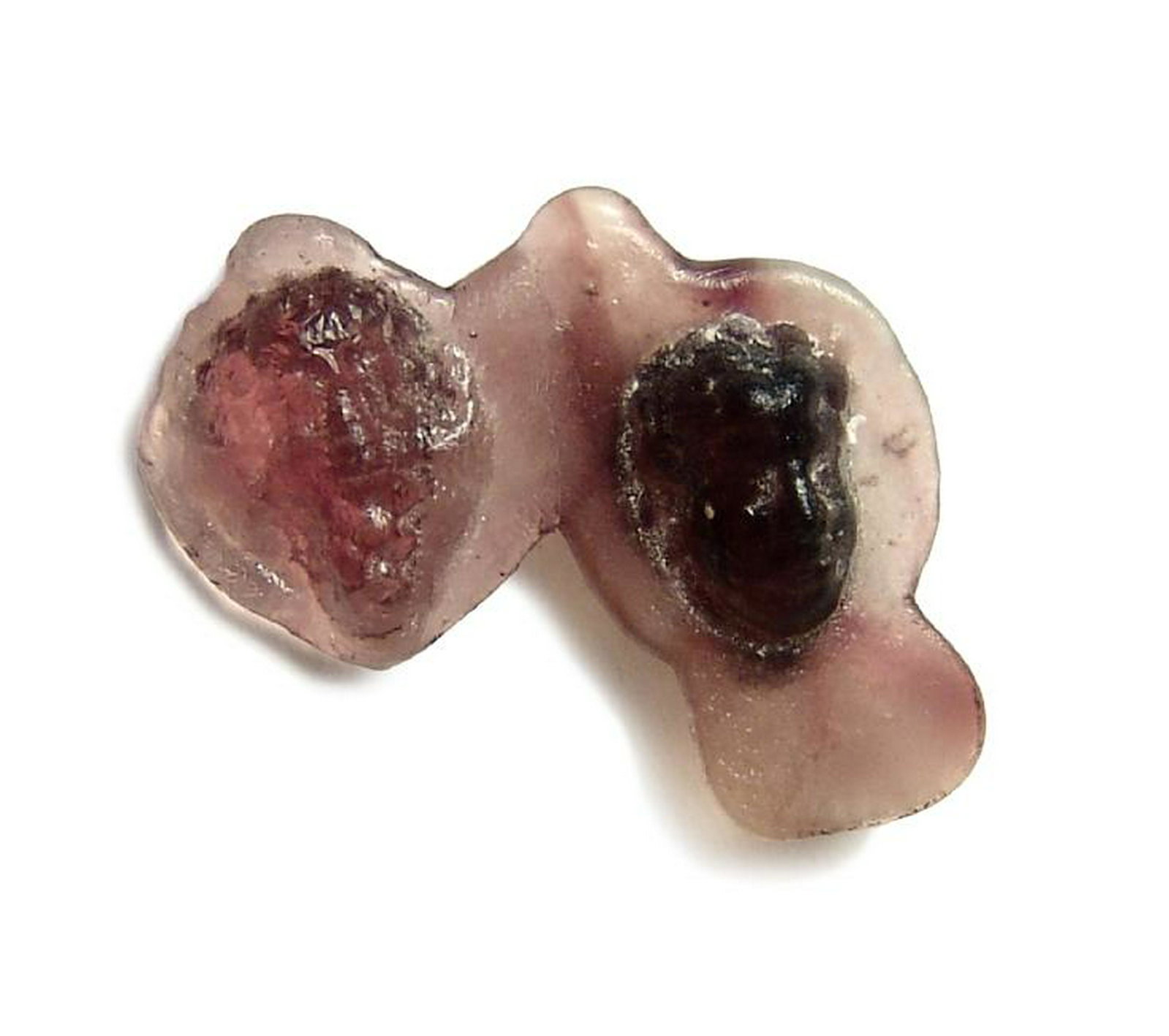 Roman purple glass molded head and bunch of grapes: A Roman purple glass molded head and bunch of grapes, c. 1st - 3rd Century AD, the glass translucent and the pair molded together for use in jewelry or similar, the flange around them indicating they 