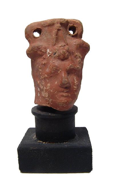 An Egyptian ceramic head flask, Ptolemaic: An Egyptian ceramic head flask, Ptolemaic, 2nd - 1st Century BC, in the form of the head of Hermes, with short-cropped hair, handsome features and wearing a winged headdress. The head is surmounted by