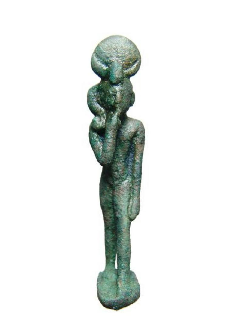 An Egyptian bronze figure of a striding Harpokrates: An Egyptian bronze figure of a striding Harpokrates, Late Period, c. 664 - 332 BC, depicted nude on integral base, wearing solar disc and horns with uraeus and side-lock of youth. His right finger is 