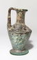 A Roman blue-green glass single-handled bottle
