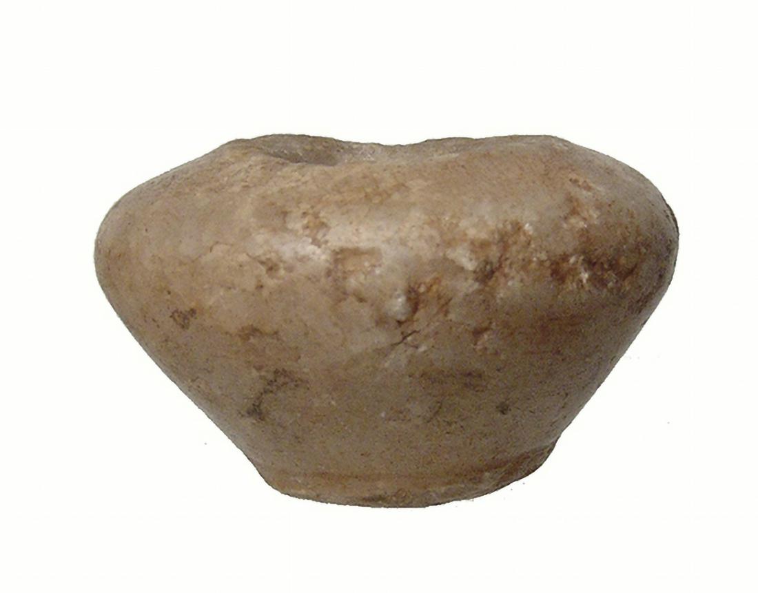 Egyptian squat alabaster kohl vessel, Old Kingdom: An Egyptian squat alabaster kohl vessel, Old Kingdom, c. 2686 - 2134 BC, with wide, rounded shoulder and narrow bottom with pad base, the interior bored vertically with short rounded rim. H: 1 1/4 in 
