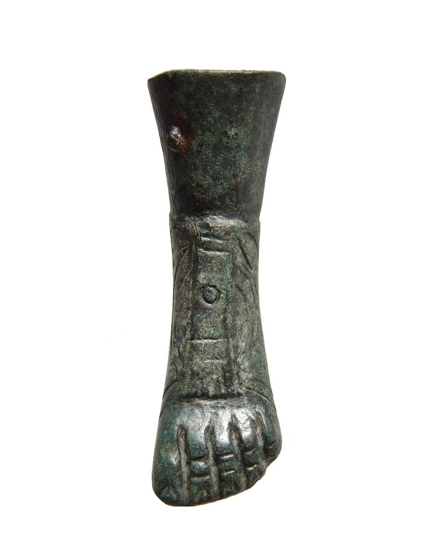 A Roman bronze foot from a statue: A Roman bronze foot from a statue, c. 1st - 4th Century AD, wearing a detailed sandal with ornate upper, the toes nicely incised and remains of an iron attachment pin near the top. L: 3 in (7.6 cm). N