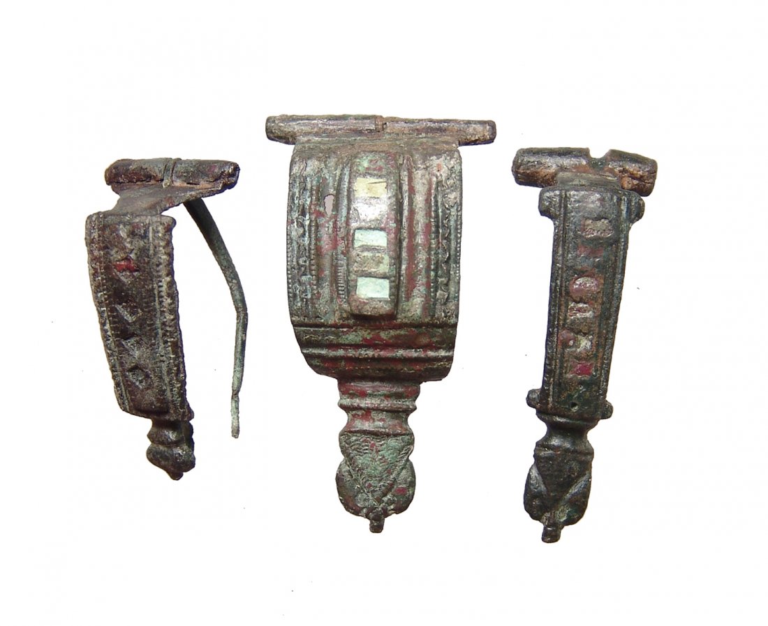 A lot of 3 Roman enameled bronze hinge brooches: A lot of 3 Roman enameled bronze hinge brooches, c. 1st - 2nd Century AD, each with preserved colored enamel inlays on the body and original pin and catch. Largest 2 in (5 cm). Nicely patinated. Ex Pe