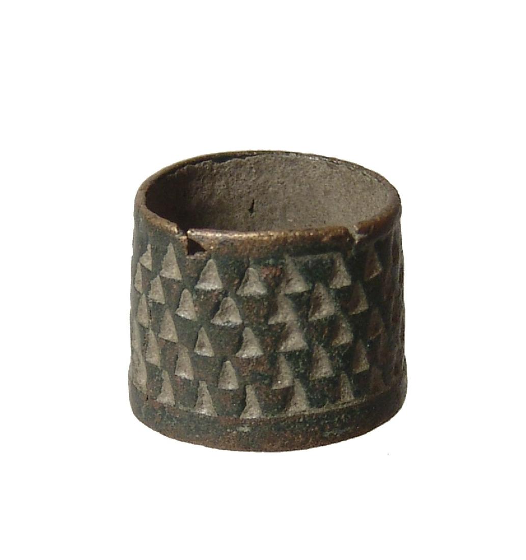 A neat bronze sewing thimble, Medieval Europe: A neat bronze sewing thimble, Medieval Europe, c. 9th-14th century AD, well-preserved and intact, the surface covered with small triangular indentations. W: 2 cm, about a US size 5, olive-green patina