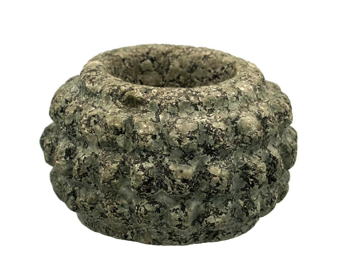A choice Jalisco mace head from West Mexico: A choice Jalisco mace head from West Mexico, c. 200 BC - AD 350, finely carved and featuring three rows of low spikes. Dia: 2 in (5 cm). Made from gray-green speckled stone and showing strong mineral 