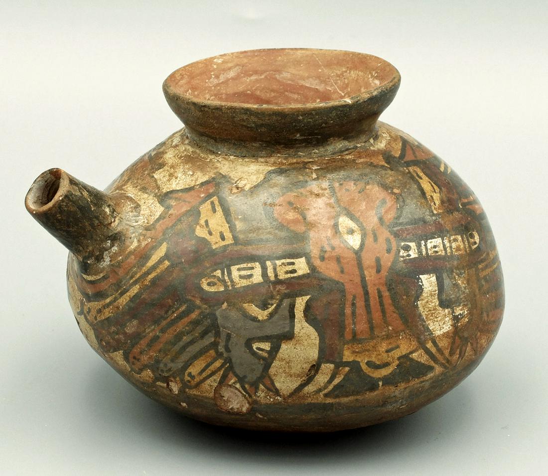 A rare Nazca pouring vessel: A rare Nazca pouring vessel, c. AD 200 - 400, an unusual example with a secondary interior wall and is decorated with two depictions of the Horrible Bird motif. Each is shown with several trophy heads