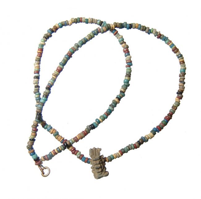 A lovely Egyptian faience bead choker, Late period: A lovely Egyptian faience bead choker, Late period, c. 664 - 30 BC, the multicolored faience tube and disk beads of extremely high quality with an amulet pendant of the god Bes. L: 16 in (40.6 cm). A 