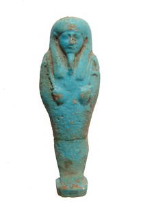 Egyptian light blue glazed ushabti, Late Period: An Egyptian light blue glazed ushabti, Late Period, c. 664 - 30 BC, frontally molded and depicted mummiform, wearing tripartite headdress and false beard, arms folded at chest and holding a pick and