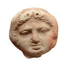 Greek terracotta roundel depicting face of a Gorgon