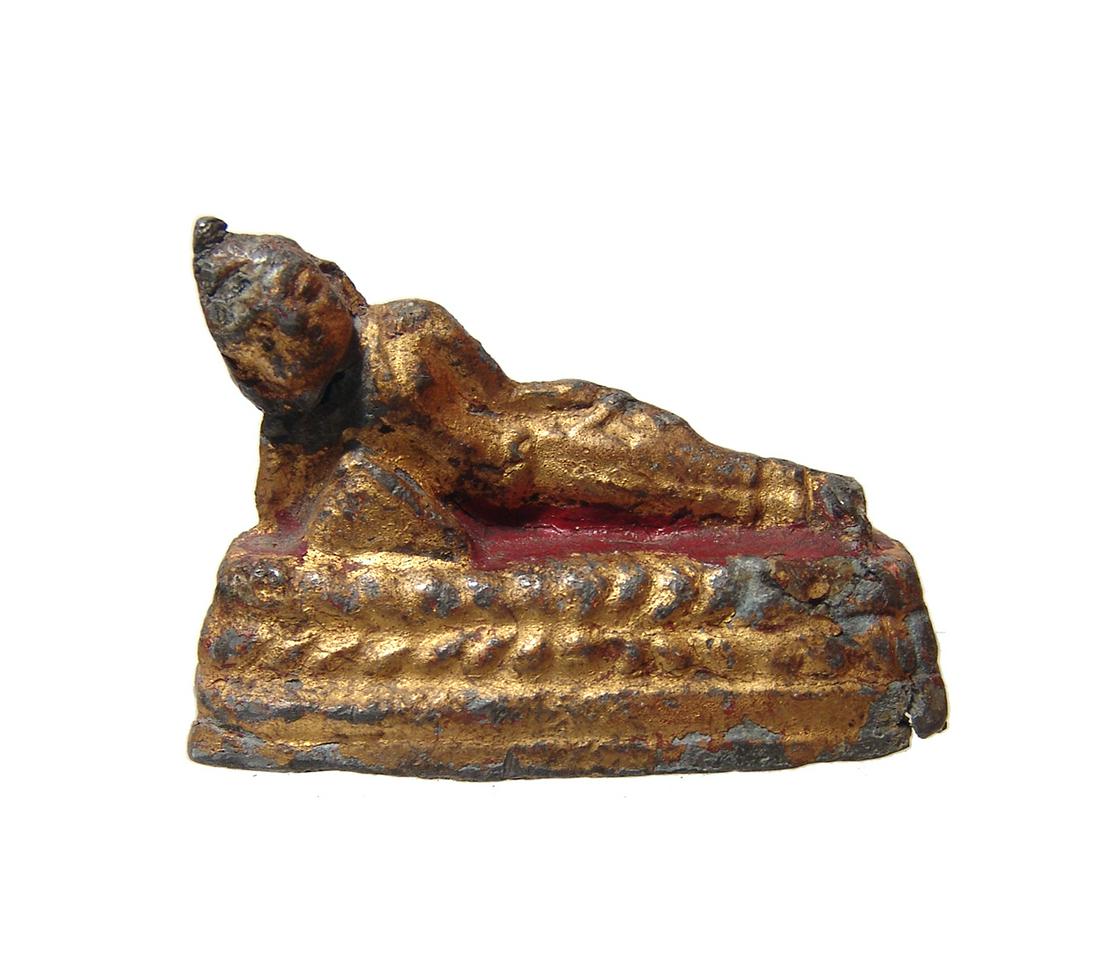 A little gilded figure of Buddha reclined on a bed: A little gilded figure of Buddha reclined on a bed, early 20th Century, with good detail and remnants of red pigment. 1 3/4 x 2 5/8 in (4.5 x 6.7 cm). Ex Los Angeles private collection.