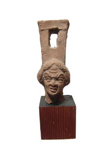 Roman sistrum handle with head of female grotesque: A choice Roman ceramic sistrum handle with head of female grotesque, Egypt, 1st - 2nd Century AD, with fantastic detail and with expressive features, the rectangular attachment atop her head pierced