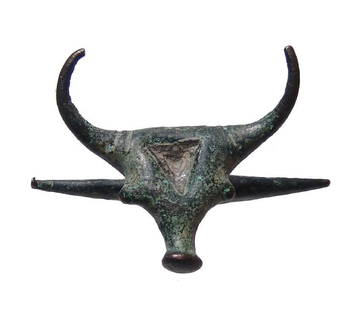 An Anatolian bronze head of a bull: An Anatolian bronze head of a bull, c. 2200 - 2000 BC, with flattened head with triangular recession for inlay, wide horns turned upward, protruding eyes and long tubular muzzle. The head sits atop a