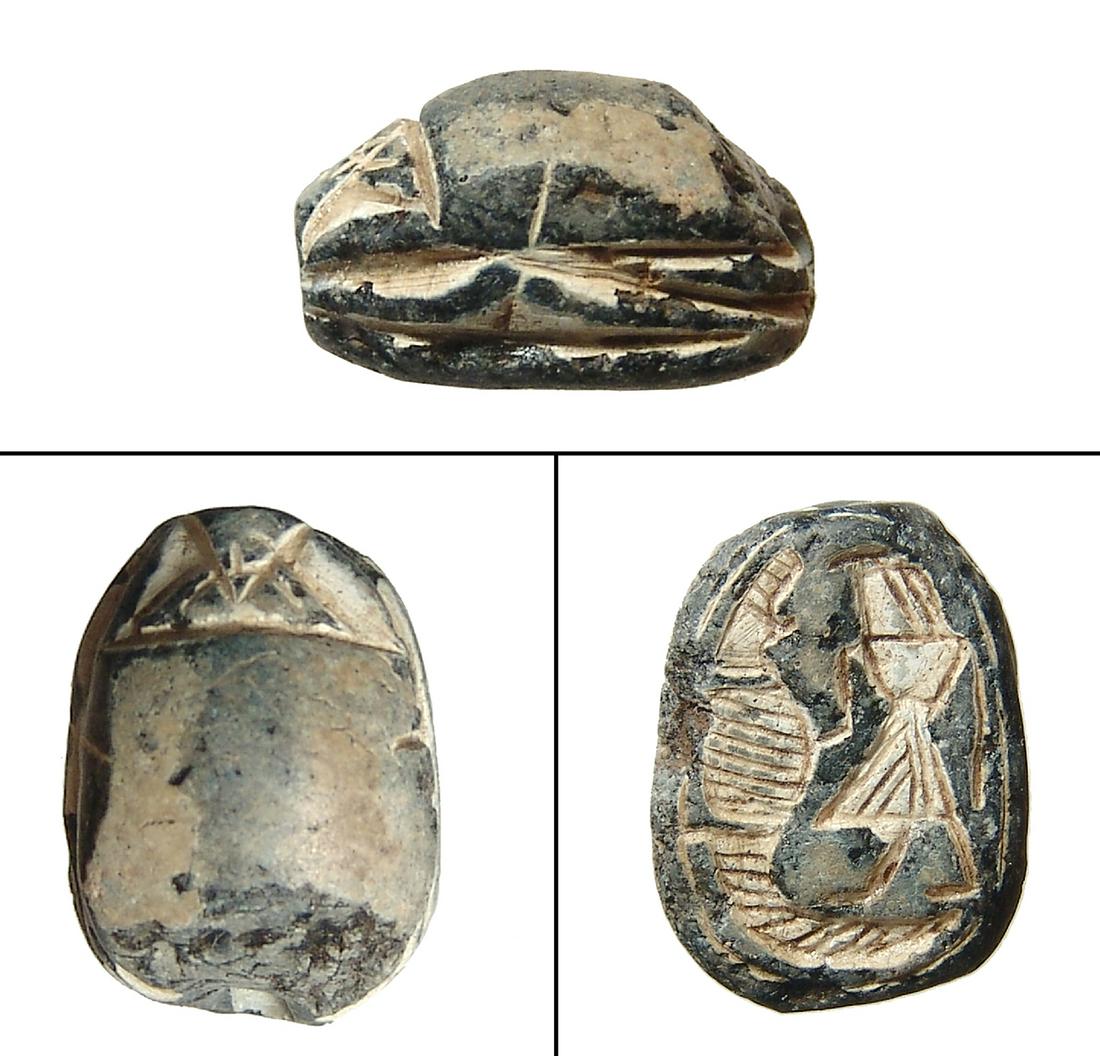 An Egyptian steatite scarab, 2nd Intermediate Period: An Egyptian steatite scarab, 2nd Intermediate Period, c. 1750 - 1570 BC, with the god Ra standing before a rampant crocodile. 23 x 15 mm. Light deposits holed lengthwise for suspension. Ex North Carol