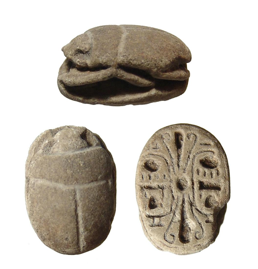 An Egyptian faience scarab in name of Thutmose III: An Egyptian faience scarab in name of Thutmose III, New Kingdom, c. 1479 - 1075 BC, of pleasant style, on base a pair of cartouches with the praenomen of Thutmose III, 'Men-Kheper-Ra' flanking a centr