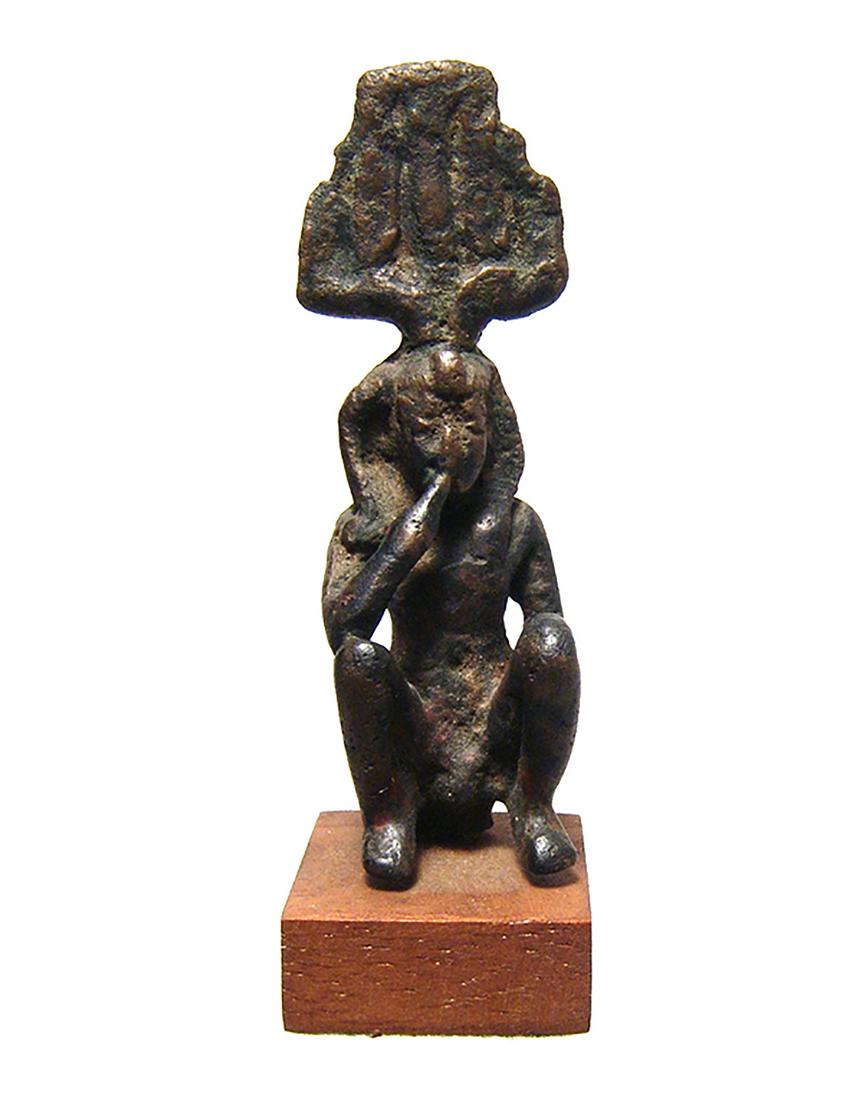 A rare Egyptian bronze depiction of Harpokrates: A rare Egyptian bronze depiction of Harpokrates, Late Period, c. 664 - 332 BC, seated and wearing Hem Hem crown with uraeus and side-lock of youth, right finger pressed to his lips, left hand resting 
