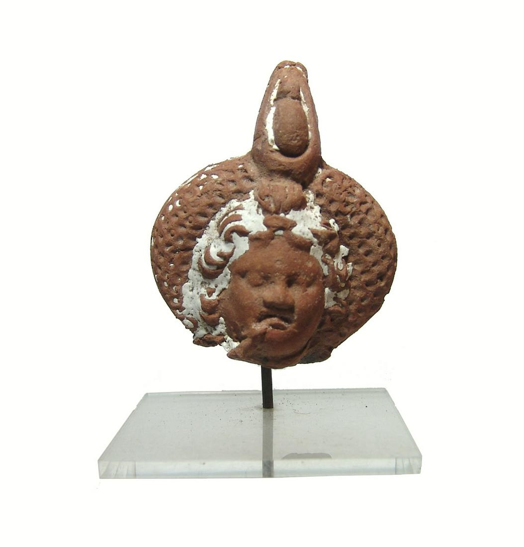 Egyptian terracotta head of Harpokrates, Ptolemaic: A nice Egyptian terracotta head of Harpokrates, Ptolemaic, 3rd - 2nd Century BC, wearing large wreath surmounted a stylized double crown of Upper and Lower Egypt. His features are beautifully detailed